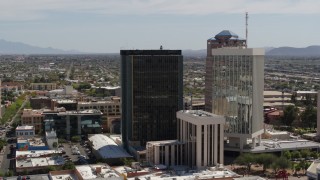 DX0002_144_018 - 5.7K aerial stock footage of orbiting and flying away from tall office high-rises in Downtown Tucson, Arizona