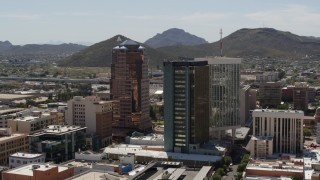 DX0002_144_020 - 5.7K aerial stock footage orbiting office towers with Sentinel Peak behind them, Downtown Tucson, Arizona