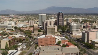 DX0002_144_034 - 5.7K aerial stock footage focus on tall office high-rises surrounded by city buildings in Downtown Tucson, Arizona