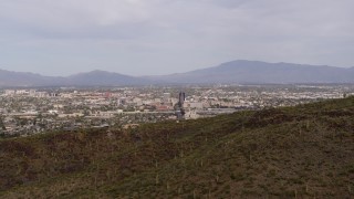 DX0002_145_012 - 5.7K aerial stock footage the city of Tucson seen while descending behind Sentinel Peak, Arizona