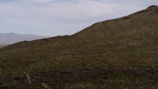 DX0002_145_014 - 5.7K aerial stock footage of flying away from cactus and vegetation on Sentinel Peak in Tucson, Arizona