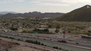 DX0002_145_026 - 5.7K aerial stock footage pan across I-10 freeway to reveal Sentinel Peak in Tucson, Arizona