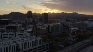 DX0002_146_029 - 5.7K aerial stock footage flying away from office towers at sunset in Downtown Tucson, Arizona