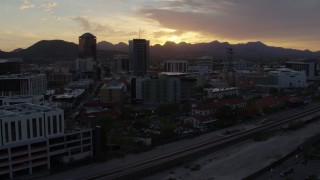 DX0002_146_032 - 5.7K aerial stock footage flying by tall office towers and city buildings at sunset in Downtown Tucson, Arizona