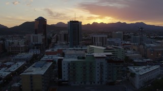 DX0002_146_040 - 5.7K aerial stock footage orbit and fly away from high-rise office towers and setting sun in Downtown Tucson, Arizona