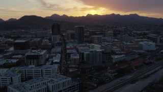 DX0002_146_041 - 5.7K aerial stock footage fly away from and past high-rise office towers with view of Sentinel Peak at sunset in Downtown Tucson, Arizona
