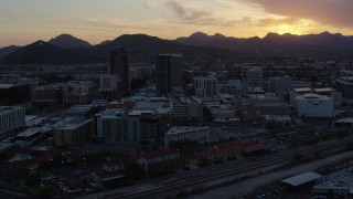 DX0002_146_042 - 5.7K aerial stock footage of high-rise office towers and Sentinel Peak at sunset in Downtown Tucson, Arizona