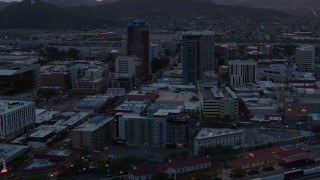 DX0002_147_005 - 5.7K aerial stock footage flying by high-rise office towers at sunset with Sentinel Peak in distance, Downtown Tucson, Arizona