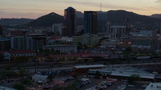 DX0002_147_006 - 5.7K aerial stock footage passing high-rise office towers at sunset with Sentinel Peak in distance, Downtown Tucson, Arizona