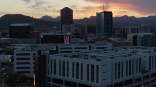 DX0002_147_008 - 5.7K aerial stock footage of a view of high-rise office towers at sunset with mountains in distance, Downtown Tucson, Arizona