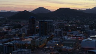 DX0002_147_019 - 5.7K aerial stock footage of passing tall office towers at sunset, Sentinel Peak in the distance, Downtown Tucson, Arizona