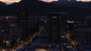 DX0002_147_033 - 5.7K aerial stock footage circling tall office towers and reveal Congress Street at twilight, Downtown Tucson, Arizona