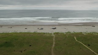 DX0002_148_007 - 4K aerial stock footage of approaching people on the beach and ocean in Long Beach, Washington