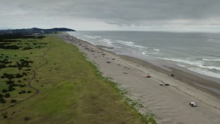 DX0002_148_010 - 4K aerial stock footage approach people on the beach in Long Beach, Washington