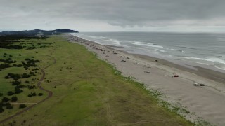 DX0002_148_011 - 4K aerial stock footage reverse view of people on the beach in Long Beach, Washington