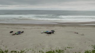 DX0002_148_014 - 4K aerial stock footage fly away from people on the beach and ocean in Long Beach, Washington