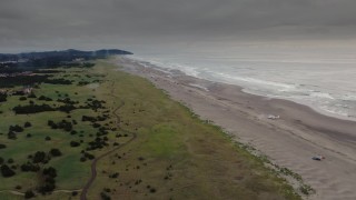 DX0002_148_019 - 4K aerial stock footage of flying away from beach-goers in Long Beach, Washington