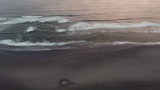 DX0002_148_024 - 4K aerial stock footage of flying over the beach and ocean waves at sunset in Long Beach, Washington