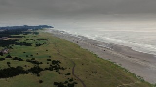 DX0002_148_029 - 4K aerial stock footage fly away from the beach and ocean waves at sunset in Long Beach, Washington
