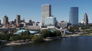 DX0002_149_031 - 5.7K aerial stock footage of tall skyscrapers seen while flying by a waterfront outdoor stage in Downtown Milwaukee, Wisconsin