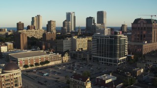DX0002_150_012 - 5.7K aerial stock footage of flying by a dormitory complex for view of skyline at sunset in Downtown Milwaukee, Wisconsin