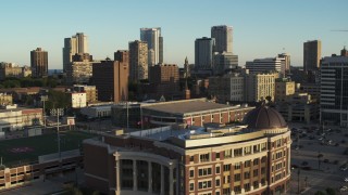 DX0002_150_014 - 5.7K aerial stock footage of ascending from a college building for a view of the skyline at sunset in Downtown Milwaukee, Wisconsin