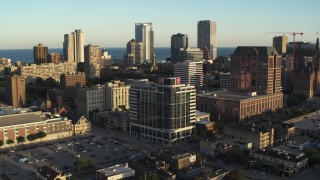 DX0002_150_016 - 5.7K stock footage aerial video passing dormitory building for view of the city's skyline at sunset, Downtown Milwaukee, Wisconsin