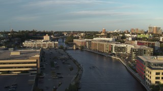 DX0002_150_024 - 5.7K aerial stock footage ascend past apartment complexes by the Milwaukee River at sunset, Milwaukee, Wisconsin