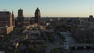 DX0002_150_028 - 5.7K aerial stock footage view of city buildings, tall office tower by the Milwaukee River at sunset, Downtown Milwaukee, Wisconsin