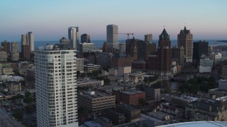 DX0002_150_031 - 5.7K aerial stock footage flying by apartment complex for view of downtown at twilight, Downtown Milwaukee, Wisconsin