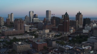 DX0002_150_032 - 5.7K aerial stock footage city buildings and skyscrapers behind office tower at twilight, Downtown Milwaukee, Wisconsin