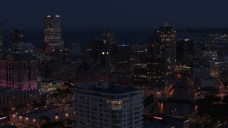 DX0002_151_006 - 5.7K aerial stock footage of skyscrapers seen while descending by apartment high-rise at night, Downtown Milwaukee, Wisconsin