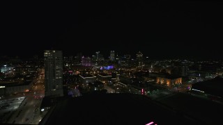 DX0002_151_013 - 5.7K aerial stock footage pan from a high-rise apartment building at night, focus on skyline, Downtown Milwaukee, Wisconsin