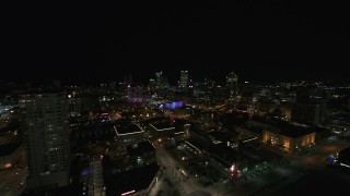 DX0002_151_020 - 5.7K aerial stock footage reverse view of the city skyline and apartment high-rise at night, Downtown Milwaukee, Wisconsin