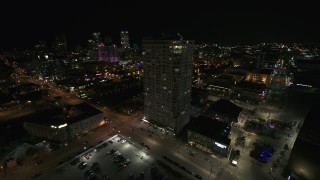 DX0002_151_024 - 5.7K aerial stock footage flying away from an apartment high-rise at night, Downtown Milwaukee, Wisconsin