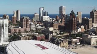 DX0002_152_029 - 5.7K aerial stock footage the city's skyline while descending by arena in Downtown Milwaukee, Wisconsin