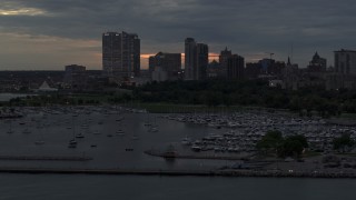 DX0002_155_029 - 5.7K aerial stock footage of ascending by the marina with a view of the city's skyline at twilight, Downtown Milwaukee, Wisconsin