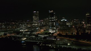 DX0002_157_003 - 5.7K aerial stock footage of passing by tall skyscrapers at night, Downtown Milwaukee, Wisconsin