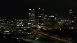 DX0002_157_004 - 5.7K aerial stock footage of flying past tall skyscrapers at night, Downtown Milwaukee, Wisconsin