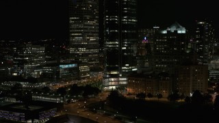 DX0002_157_032 - 5.7K aerial stock footage of the base of a tall skyscraper at night, Downtown Milwaukee, Wisconsin