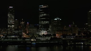 DX0002_157_034 - 5.7K aerial stock footage of a wide orbit of a towering skyscraper at night, Downtown Milwaukee, Wisconsin
