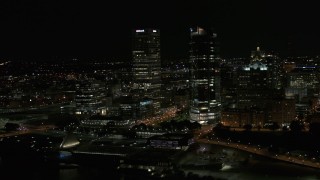 DX0002_157_038 - 5.7K aerial stock footage fly away from a pair of towering skyscrapers at night, Downtown Milwaukee, Wisconsin