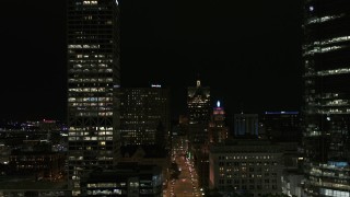 DX0002_157_050 - 5.7K aerial stock footage reverse view of Wisconsin Avenue and skyscrapers at night, Downtown Milwaukee, Wisconsin