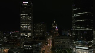 DX0002_157_051 - 5.7K aerial stock footage fly away from Wisconsin Avenue and skyscrapers at night, Downtown Milwaukee, Wisconsin