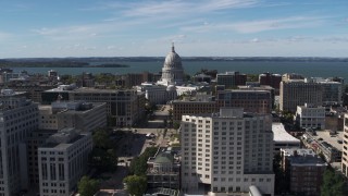 DX0002_158_028 - 5.7K aerial stock footage of slowly passing the capitol dome surrounded by office buildings, Madison, Wisconsin