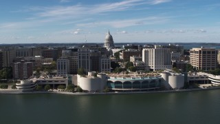 DX0002_158_031 - 5.7K aerial stock footage fly away from convention center with view of capitol dome, office buildings, Madison, Wisconsin