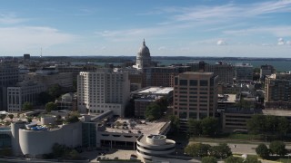 DX0002_158_033 - 5.7K aerial stock footage flyby the convention center, ascend for view of capitol dome, office buildings, Madison, Wisconsin