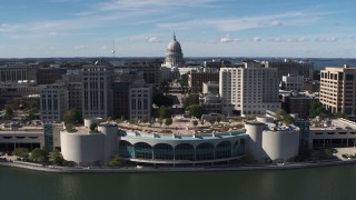 DX0002_158_036 - 5.7K aerial stock footage of the capitol dome and office buildings, seen while ascending past convention center, Madison, Wisconsin