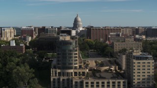 DX0002_160_022 - 5.7K aerial stock footage of flying by apartment buildings with a view of the capitol building, reveal hotel in Madison, Wisconsin