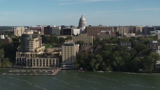 DX0002_160_024 - 5.7K aerial stock footage focus on the capitol dome while passing lakeside hotel in Madison, Wisconsin